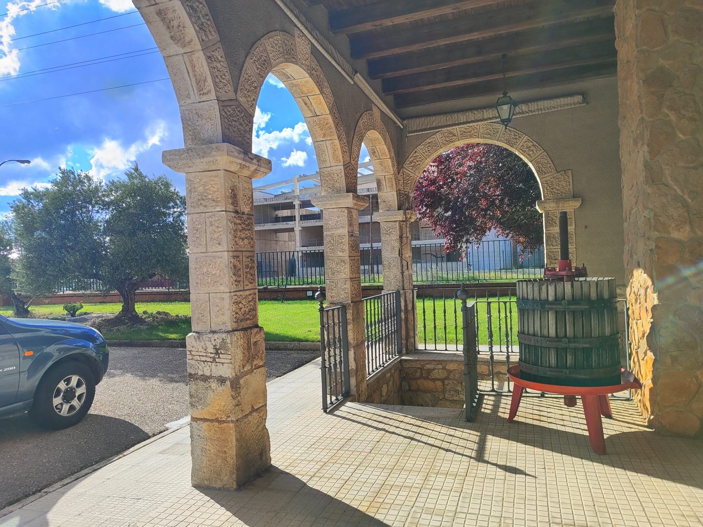 Arcos de piedra y prensa tradicional en la bodega